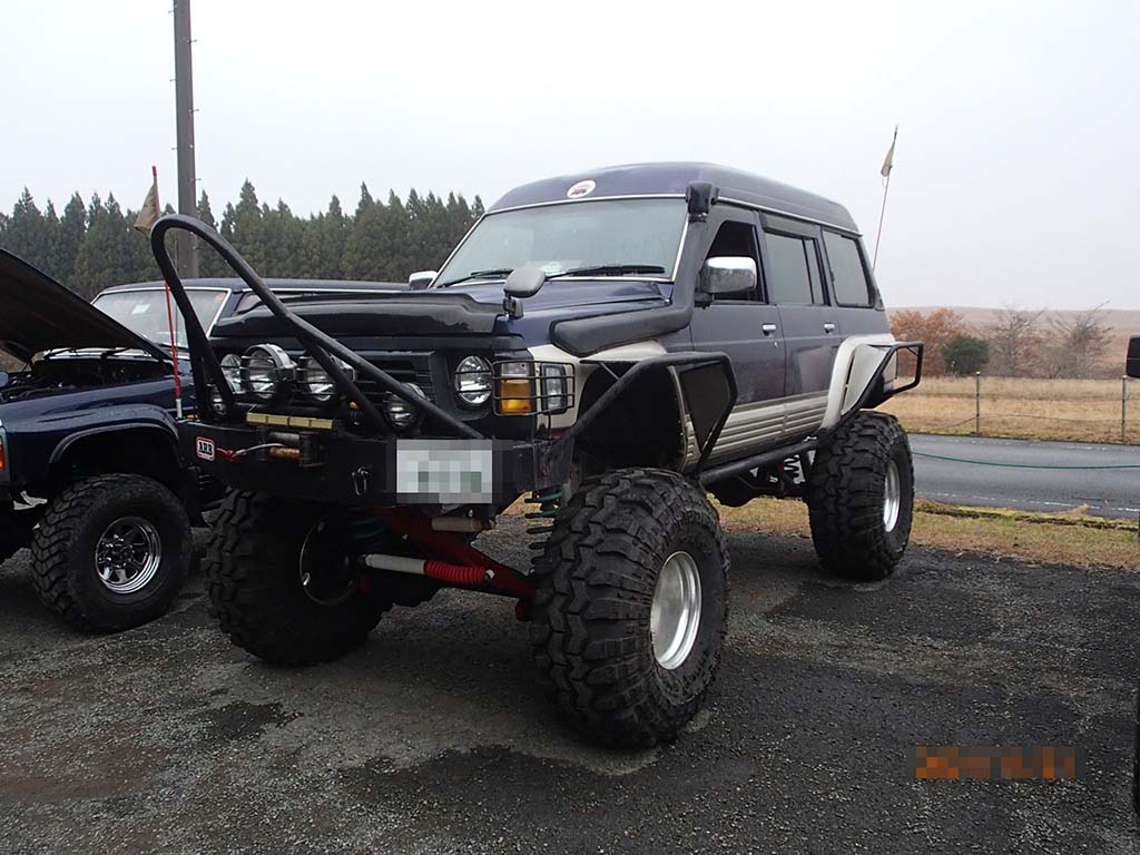 Front view of ighly modded Nissan Safari Granroad with monster tires, bull bars, custom fenders and fog lights